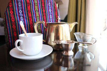 Darjeeling hi-tea set up with vintage brass teapot, white cup, and tea strainer. Green tea. refreshments with copy space.