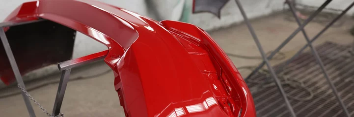 Deurstickers Painted red bumpers to drying in workshop closeup © H_Ko
