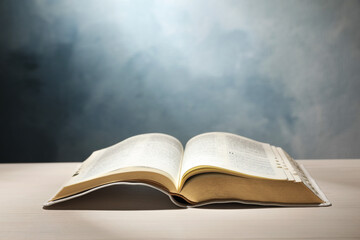 Open Bible on white wooden table against color background. Christian religious book