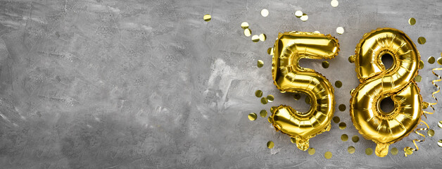 Yellow foil balloon number, number fifty eight on a concrete background. Greeting card with the...