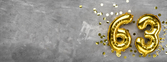 Yellow foil balloon number, number sixty three on a concrete background. Greeting card with the inscription 63. Anniversary concept. for anniversary, birthday, new year celebration. banner,