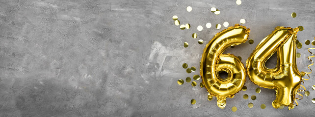 Yellow foil balloon number, number sixty four on a concrete background. Greeting card with the inscription 64. Anniversary concept. for anniversary, birthday, new year celebration. banner,