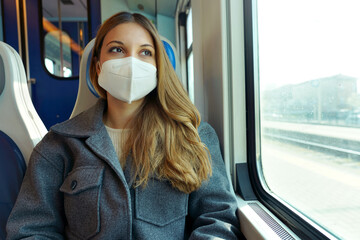 Protective mask mandatory on public transport. Portrait of young woman traveling on train looking...