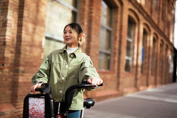 Beautiful woman getting ready for a ride. Beautiful happy lady with electric bicycle...