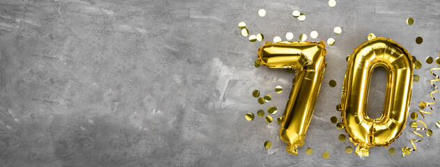 Yellow foil balloon number, number seventy on a concrete background. Greeting card with the inscription 70. Anniversary concept. for anniversary, birthday, new year celebration. banner, - obrazy, fototapety, plakaty