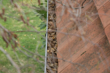Gutter full of old autumn leaves and dirt.