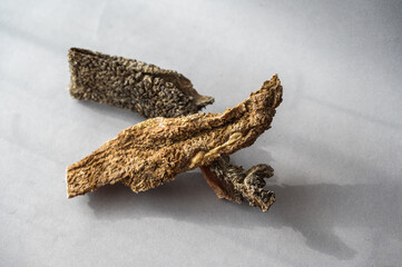 Pet treats against a gray background. Dried beef tripe. Pieces of natural, wholesome chewable dog treats.