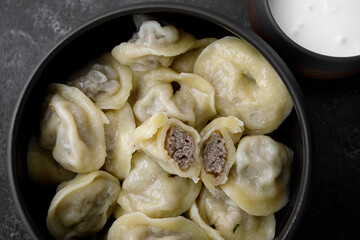 boiled dumplings with pork meat and sour cream