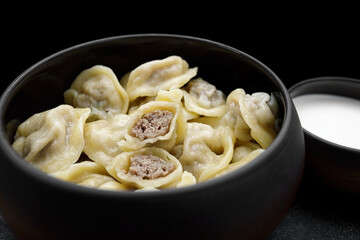 boiled dumplings with pork meat and sour cream