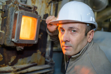 portrait of male worker next to incinerator inspection glass - obrazy, fototapety, plakaty