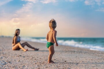 Fototapeta premium Older sister playing with younger brother aground near the shore on summer vacation