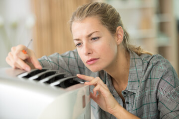 female technician fixing a machine