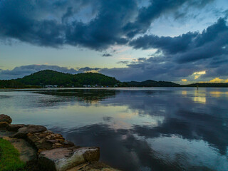 Sunrise waterscape and rain clouds reflections