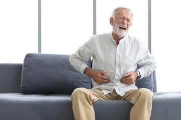 Fototapeta premium senior man have a stomachache and holding stomach on sofa