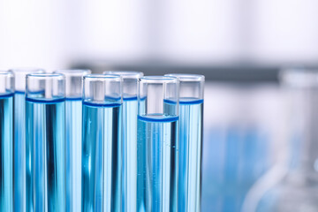 Test tubes with reagents on blurred background, closeup. Laboratory analysis