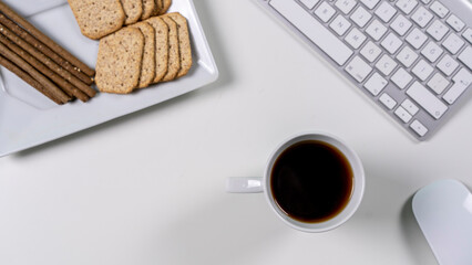
take a short break from work. in between. coffee break. Tea time. Coffee and snack on white desk.