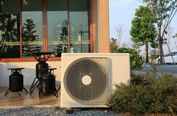 Air conditioner ourdoor condensing unit construction in front of the house see inside by glass interoir.