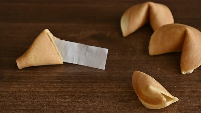 Broken fortune cookie on table with blank paper slip for your wish good luck.