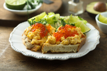 Scrambled eggs with red caviar on toast