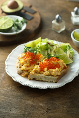 Scrambled eggs with red caviar on toast