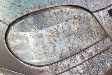Dirt-splattered SUV headlight after driving on a muddy dirt road