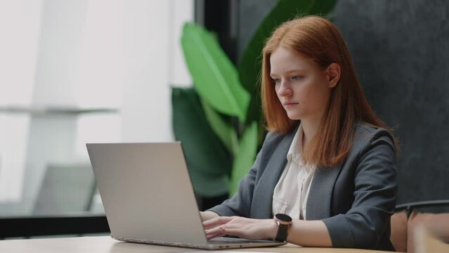 female seo specialist or lawyer is typing message on laptop and sending in work chat, successful serious woman