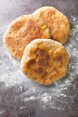 Delicious Ukrainian rustic bread Palyanytsya close-up on the table. Vertical top view from above