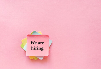 We are hiring text concept on sticky notes on pink background . Top view with copy space 