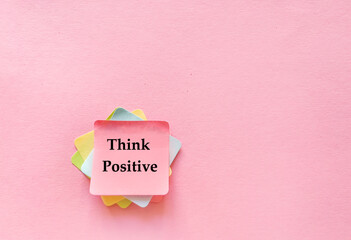 Sticky notes with think  positive message on pink background 
