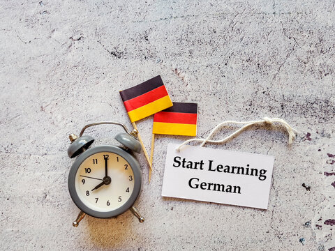 Start Learning  German Language  Education Concept with German flags ,alarm clock and message card 