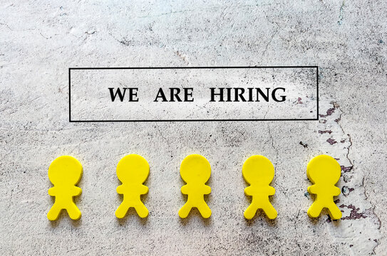 We are hiring concept with yellow people in row on grey textured background 
