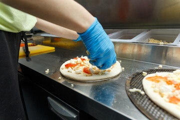 Chef preparing pizza on metal table, closeup.