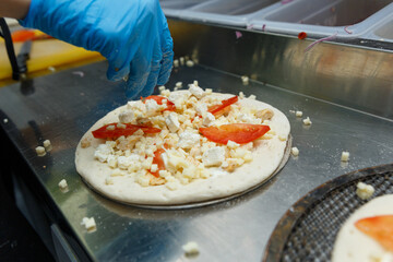 Chef preparing pizza on metal table, closeup.