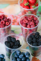 berries lie in cups on the market counter