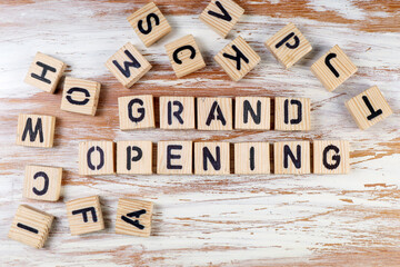 Grand Opening. Text and alphabet blocks on a wooden texture background