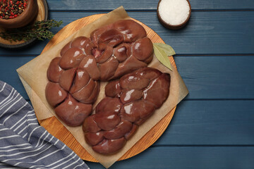 Fresh raw kidney meat, spices and thyme on blue wooden table, flat lay