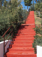 Red staircase uphill with stone steps. Bodrum. Vertical
