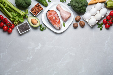Flat lay composition with keto diet products on light grey marble table, space for text