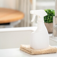 Cleaning product spray bottle in modern kitchen beside sink.