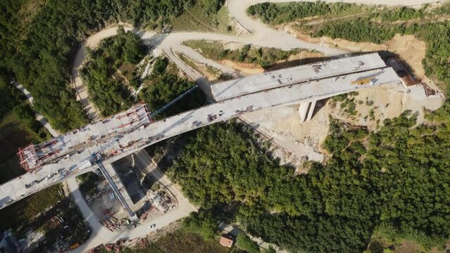 Highway bridge under construction. Aerial view of nes road. Freeway being built on a mountain terrain..