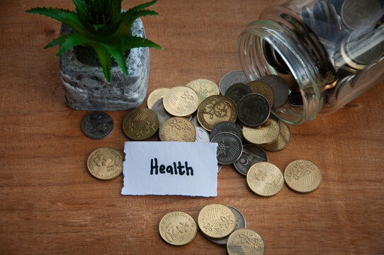 Health text on torn paper with jar, coins, and plant background. Health concept