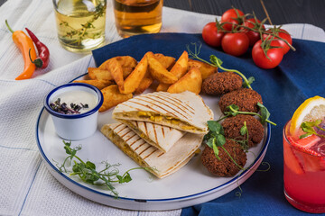 Grilled quesadillas with falafel on black wooden background