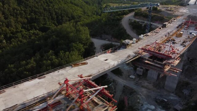 Highway bridge under construction. Aerial view of nes road. Freeway being built on a mountain terrain..