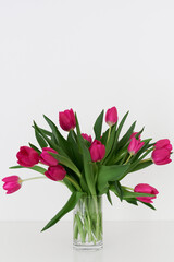 Bouquet of pink tulips in a transparent vase. Pink flowers. Minimal and simple home decor