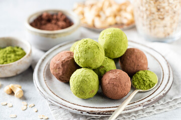 Homemade Vegan green matcha and carob truffles on plate made with nuts, dates and rolled oats. Healthy sugar free vegan paleo truffles