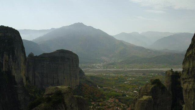 Aerial view in middle of sandstone pillars in Meteora, Greece - reverse, tilt, drone shot