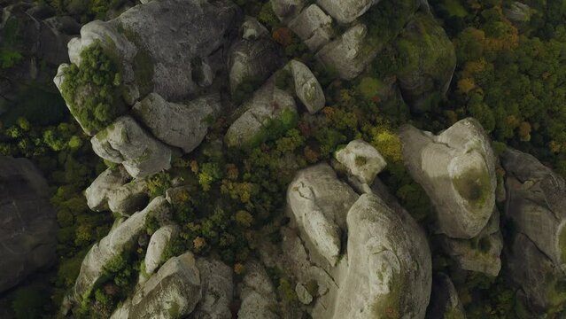 Aerial view above steep, sandstone and conglomerate cliffs in Meteora, Greece - birds eye, drone shot