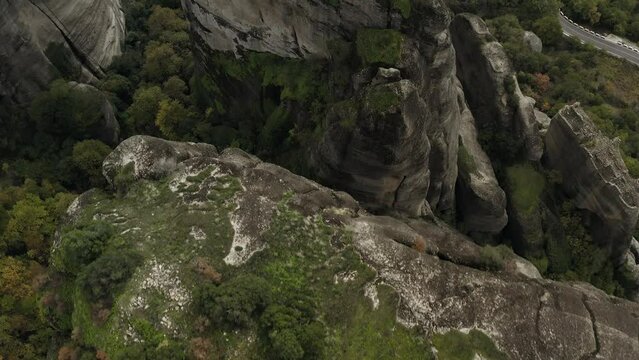 Aerial view over ravines and conglomerate cliffs in Meteora, Greece - tilt, drone shot