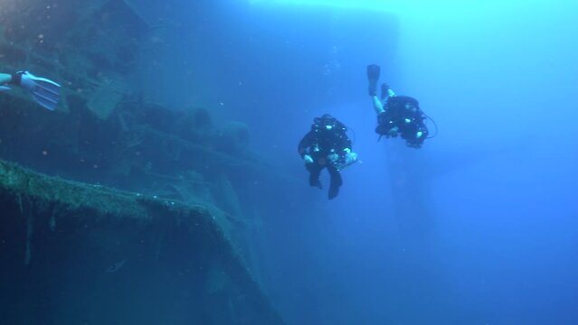 Scuba divers swims on the Shipwreck Swedish ferry MS Zenobia. Wreck diving. Mediterranean sea, Cyprus. Maritime disasters. Underwater 4K video filming Shot Of Sunken Ship. World tragedies under water