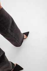 a leg in black pumps on a white background, a background with legs in black shoes (above view)